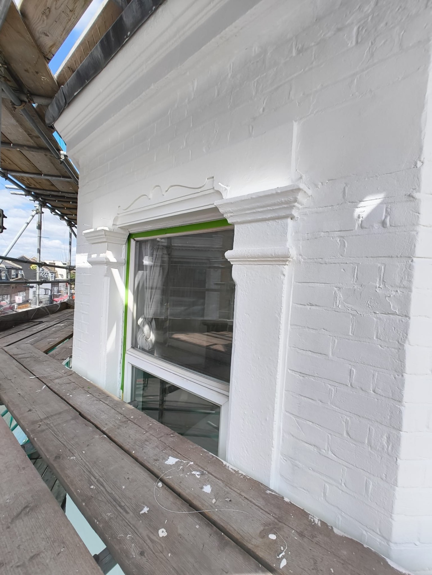 Restored window surround with masking tape still in place after decoration