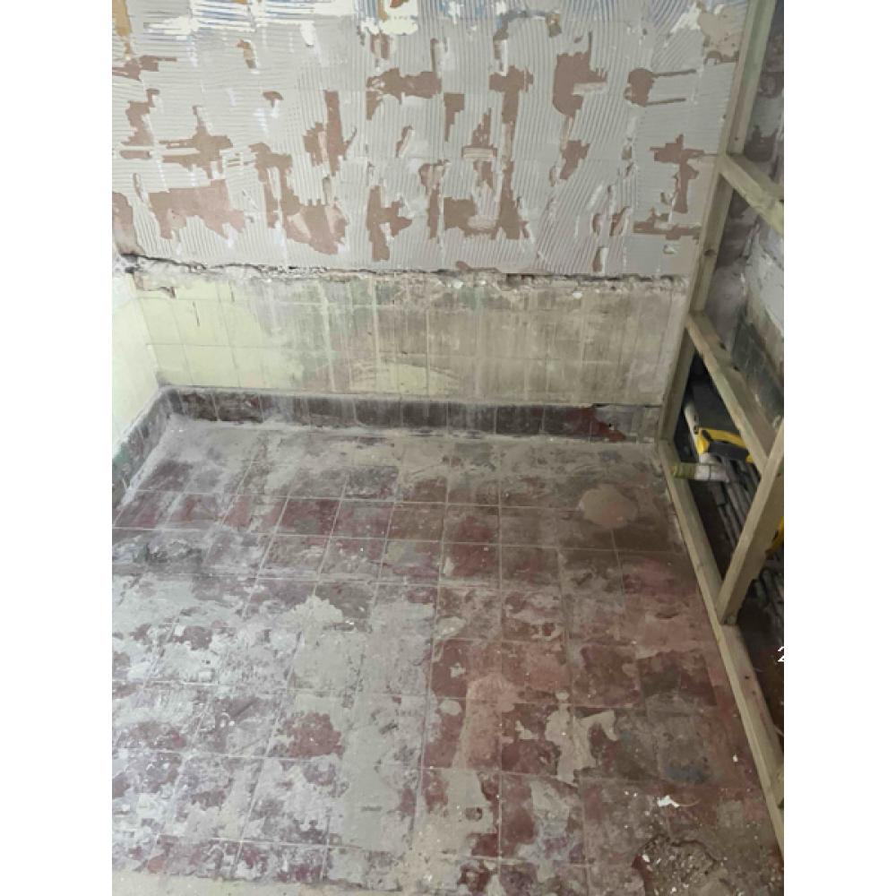 Stripped floor and wall junction prepared for new works