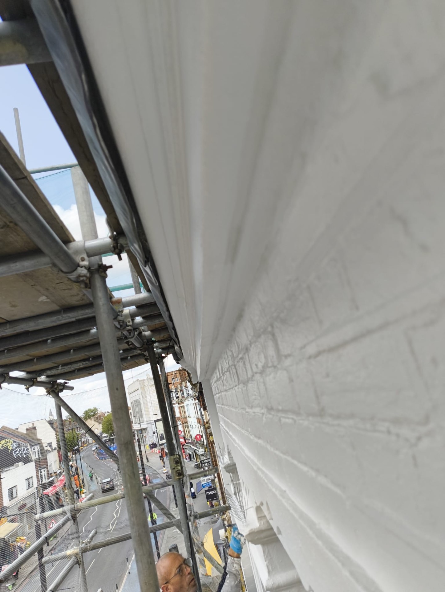 Painted cornice detail from the top scaffold lift with Upper Tooting Road below