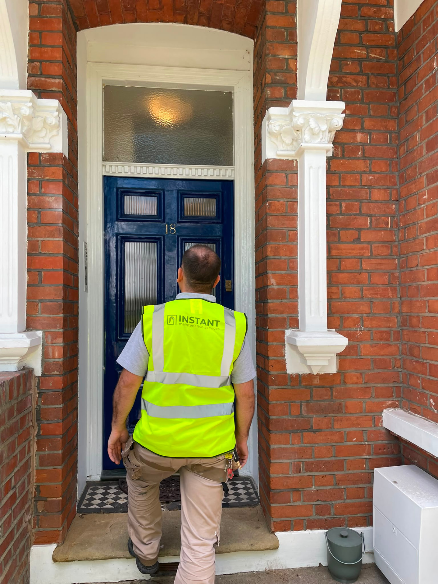 IMS engineer in branded high visibility workwear arriving at a London property