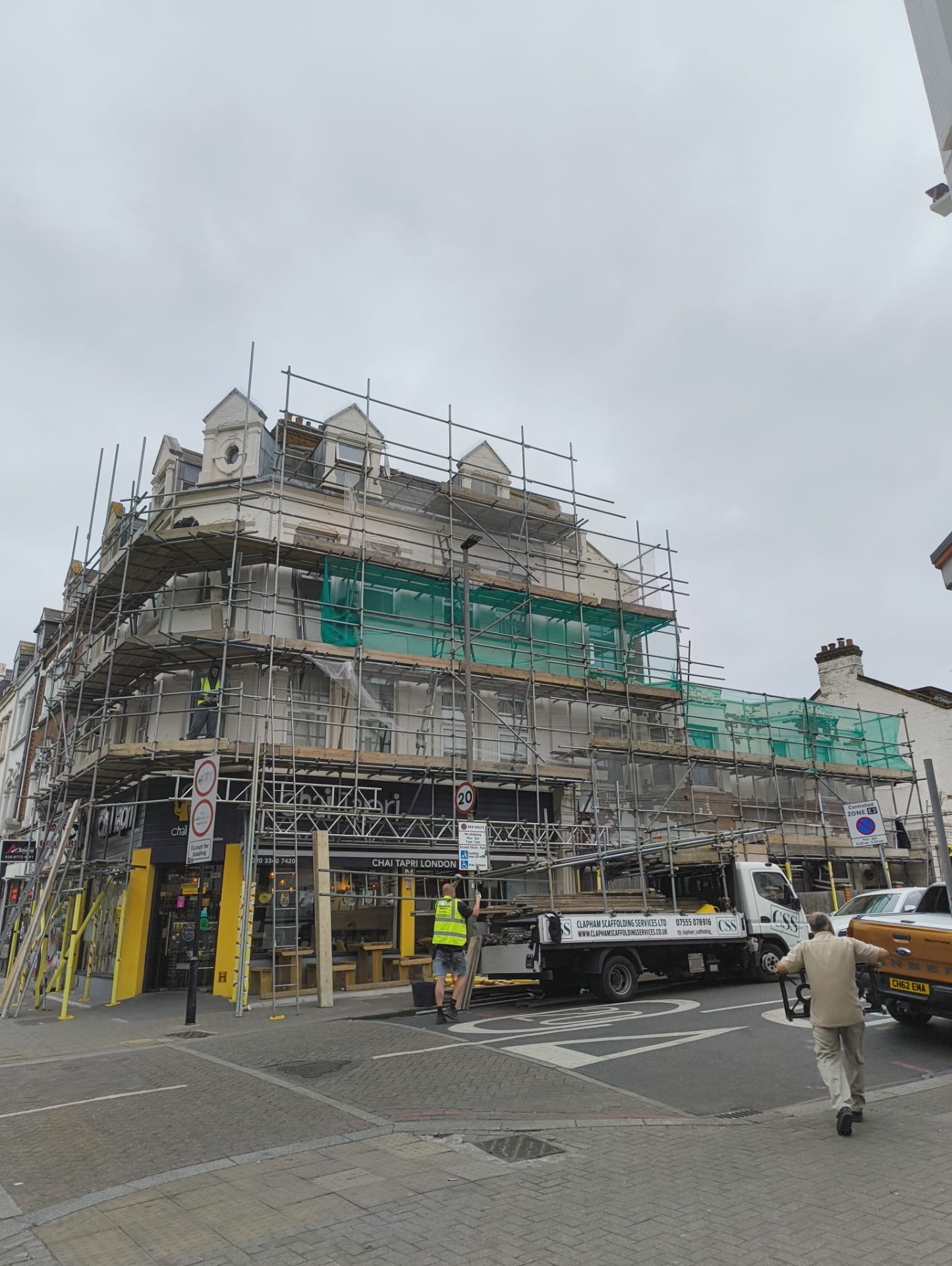 Corner block at 179 Upper Tooting Road under full scaffold with flaking paint before the works