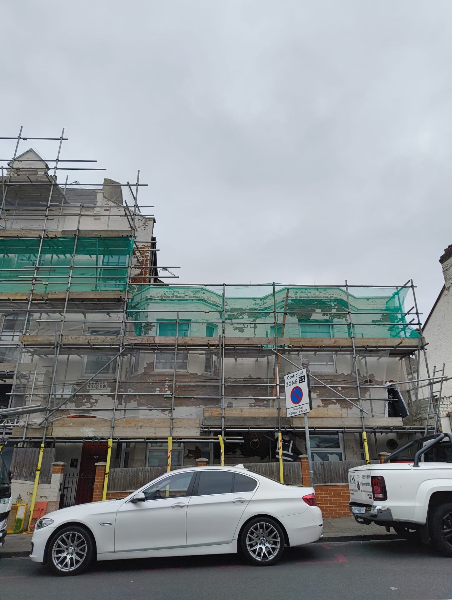 Cowick Road elevation under scaffold showing peeling paint and weather damaged masonry