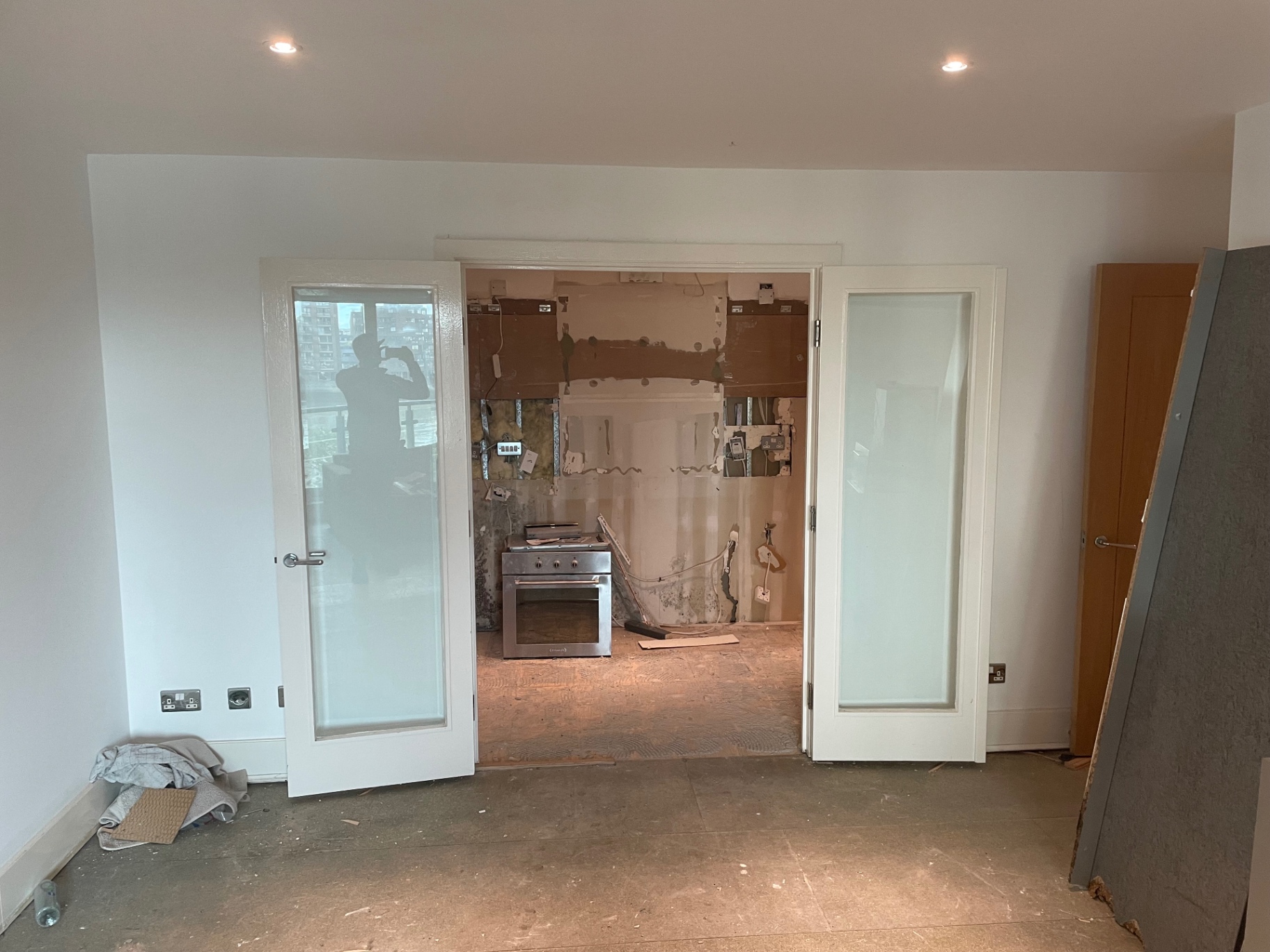 Open-plan living area looking into the stripped kitchen before the refit